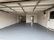 Spacious garage featuring a gray epoxy floor and ample storage space, accessible through an interior door at 855 S Revolta Cir, Mesa, AZ 85208