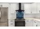 Newly renovated kitchen with white cabinetry, stainless appliances, and stylish blue tile backsplash at 855 S Revolta Cir, Mesa, AZ 85208