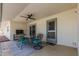 Covered outdoor patio featuring a dining set, TV, and ceiling fan at 855 S Revolta Cir, Mesa, AZ 85208