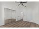 A bright bedroom features wood floors, a ceiling fan, and a closet with mirrored sliding doors at 862 W Rawhide Ave, Gilbert, AZ 85233