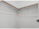 A spacious walk-in closet with wooden clothes racks and white walls, perfect for ample storage at 862 W Rawhide Ave, Gilbert, AZ 85233