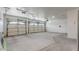 A spacious three car garage with white walls, concrete floor and updated doors at 862 W Rawhide Ave, Gilbert, AZ 85233