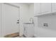 Well-lit laundry room boasts white cabinets, sink, and utility connections, for efficient chores at 862 W Rawhide Ave, Gilbert, AZ 85233