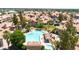 Aerial view of resort-style community pool and lush green landscaping amongst residential condos and mature trees at 1001 N Pasadena Dr # 105, Mesa, AZ 85201