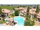 Aerial view of a resort-style community pool surrounded by lush landscaping and stylish red-tiled roofed condos at 1001 N Pasadena Dr # 105, Mesa, AZ 85201