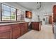 Well-lit kitchen showcasing stainless steel appliances, warm wood cabinetry, and tile flooring at 1001 N Pasadena Dr # 105, Mesa, AZ 85201
