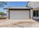 A two car garage door with trim, accented by stone veneer, that provides secure parking at 1017 S San Jose Cir, Mesa, AZ 85202