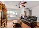 Relaxing living room featuring a ceiling fan, leather sofa, and bright natural light at 1017 S San Jose Cir, Mesa, AZ 85202