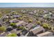 Desert neighborhood aerial view with brown houses and pool surrounded by lush desert landscaping at 10276 E Meandering Trail Ln, Gold Canyon, AZ 85118