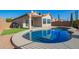 Backyard view with a sparkling pool, low-maintenance landscaping, and covered patio at 10276 E Meandering Trail Ln, Gold Canyon, AZ 85118