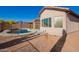 Home's backyard features a pool and covered patio with desert landscaping and mountain views at 10276 E Meandering Trail Ln, Gold Canyon, AZ 85118