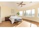 Bright bedroom with a ceiling fan, large windows, wood floors, a comfortable bed, and desert views at 10276 E Meandering Trail Ln, Gold Canyon, AZ 85118