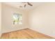 Sunlit bedroom featuring woodgrain floors and a large window with neighborhood views at 10276 E Meandering Trail Ln, Gold Canyon, AZ 85118