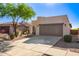 Charming single-story home with a two-car garage, desert landscaping, and a mature shade tree at 10276 E Meandering Trail Ln, Gold Canyon, AZ 85118