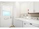 Laundry room with modern appliances and a door leading to the outside at 10921 W Santa Fe Dr, Sun City, AZ 85351