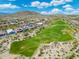 Expansive aerial view of a desert community adjacent to a lush golf course and the desert mountain range at 12027 S 183Rd Dr, Goodyear, AZ 85338