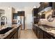 Well-equipped kitchen with sleek stainless steel appliances, dark cabinets, and granite countertops at 12027 S 183Rd Dr, Goodyear, AZ 85338