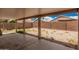Spacious backyard with a covered patio, concrete flooring, and low-maintenance desert landscaping at 12034 W Aster Dr, El Mirage, AZ 85335