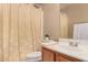 Bright bathroom featuring a shower-tub combo and a vanity sink with daisy-patterned shower curtain at 12034 W Aster Dr, El Mirage, AZ 85335