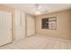 Spacious bedroom featuring tile floors, a ceiling fan, built-in storage, and a bright window at 12034 W Aster Dr, El Mirage, AZ 85335