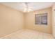 Sunny bedroom with a ceiling fan, window, tile floors and plenty of room for personalization at 12034 W Aster Dr, El Mirage, AZ 85335