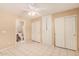 Bright bedroom featuring tile floors, a ceiling fan, built-in storage, and dual closets for optimal organization at 12034 W Aster Dr, El Mirage, AZ 85335