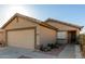 Home exterior features a two car garage, drought resistant front yard landscaping and covered entry at 12034 W Aster Dr, El Mirage, AZ 85335