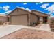 Single-story home with a two-car garage, desert landscaping and a neutral color scheme at 12034 W Aster Dr, El Mirage, AZ 85335