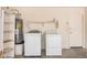 Functional laundry area with appliances and a water heater, accompanied by some storage shelves at 12034 W Aster Dr, El Mirage, AZ 85335