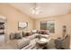 This is a virtually staged light-filled living room with tile floors, ceiling fan, and comfortable furniture at 12034 W Aster Dr, El Mirage, AZ 85335
