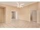 Tiled living room with a ceiling fan, arched doorway, and bright, neutral paint at 12034 W Aster Dr, El Mirage, AZ 85335