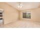 Bright living room with tile floors, a ceiling fan, and a large window overlooking the backyard at 12034 W Aster Dr, El Mirage, AZ 85335