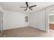 Bright bedroom with a ceiling fan, neutral carpet, and an ensuite bathroom at 1220 S Wagon Wheel Dr, Chandler, AZ 85286