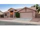 Inviting single-story home with a tile roof, a two-car garage, and a well manicured front yard at 1220 S Wagon Wheel Dr, Chandler, AZ 85286