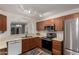 Efficient kitchen with stainless steel appliances, wood cabinets, and an open view to the dining area at 1220 S Wagon Wheel Dr, Chandler, AZ 85286