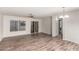 A spacious living room featuring stylish wood-look flooring, bright natural light, and a modern ceiling fan at 1220 S Wagon Wheel Dr, Chandler, AZ 85286