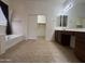 Bright bathroom with a soaking tub, a walk in closet, and vanity with good lighting at 1248 W Deoni Trl, San Tan Valley, AZ 85143
