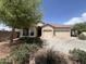 Charming home exterior with a well-manicured lawn, desert landscaping and a three car garage at 1248 W Deoni Trl, San Tan Valley, AZ 85143