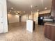 Spacious kitchen with dark cabinets, tile flooring, stainless steel appliances, and eat-in island at 1248 W Deoni Trl, San Tan Valley, AZ 85143