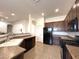 Well-equipped kitchen featuring dark cabinets, modern appliances, and durable tile flooring at 1248 W Deoni Trl, San Tan Valley, AZ 85143