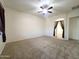 Spacious living room features carpet, ceiling fan and large window with stylish curtains at 1248 W Deoni Trl, San Tan Valley, AZ 85143