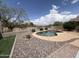 Beautiful backyard pool with desert landscaping, rock accents, and a secure metal fence at 1248 W Deoni Trl, San Tan Valley, AZ 85143