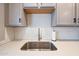 A kitchen sink, subway tile backsplash, and white quartz countertops at 12627 N 25Th Ave, Phoenix, AZ 85029