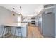 Well-lit kitchen showcasing stainless steel appliances, grey cabinets, breakfast bar with seating and wood-look flooring at 12627 N 25Th Ave, Phoenix, AZ 85029