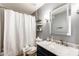 Well-lit bathroom with gray walls, a white shower curtain, and a vanity featuring a marble countertop at 1310 E Helena Dr, Phoenix, AZ 85022