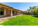 Large backyard with covered patio, lush green lawn, and desert landscaping at 13213 W Jacobson Dr, Litchfield Park, AZ 85340