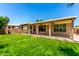 Spacious backyard featuring a covered patio and lawn, perfect for outdoor living and entertainment at 13213 W Jacobson Dr, Litchfield Park, AZ 85340