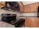A close-up view of the kitchen features oak cabinets, a black microwave, and a flat top electric range at 13213 W Jacobson Dr, Litchfield Park, AZ 85340