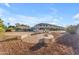 Backyard with gravel landscaping, mature trees, and custom firepit area at 13304 W Palo Verde Dr, Litchfield Park, AZ 85340