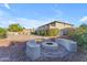Backyard with gravel landscaping, mature trees, and custom firepit area at 13304 W Palo Verde Dr, Litchfield Park, AZ 85340